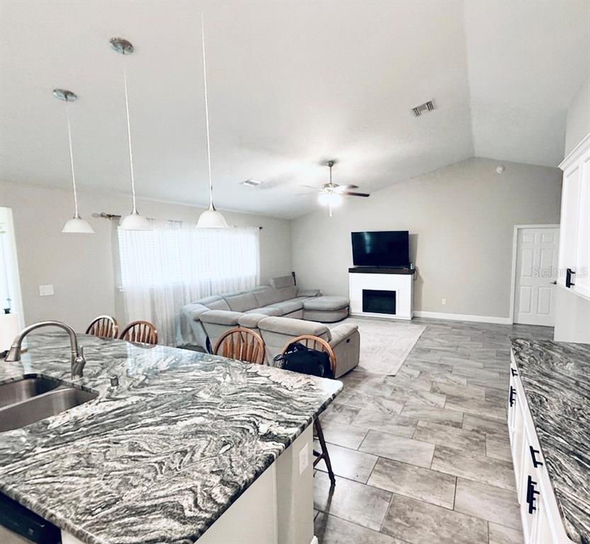 A single-story house with a beige exterior, a red front door, and a two-car garage — 5601 SW 117TH LANE ROAD, OCALA, FL