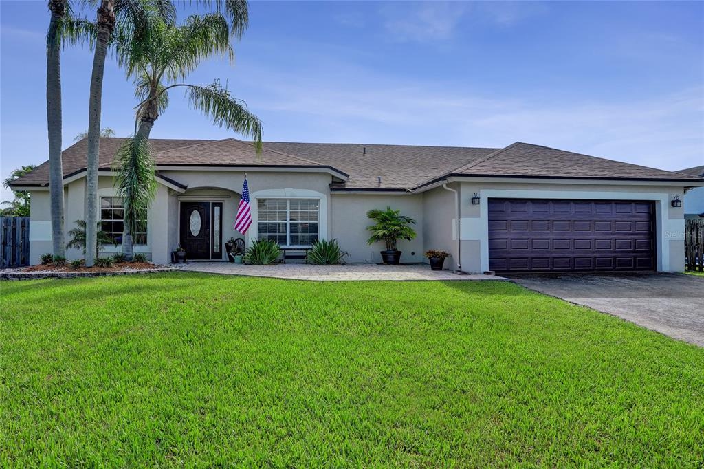 A single-story house with a brown roof, beige stucco exterior, and a two-car garage — 1156 SW 149 LANE, SUNRISE, FL