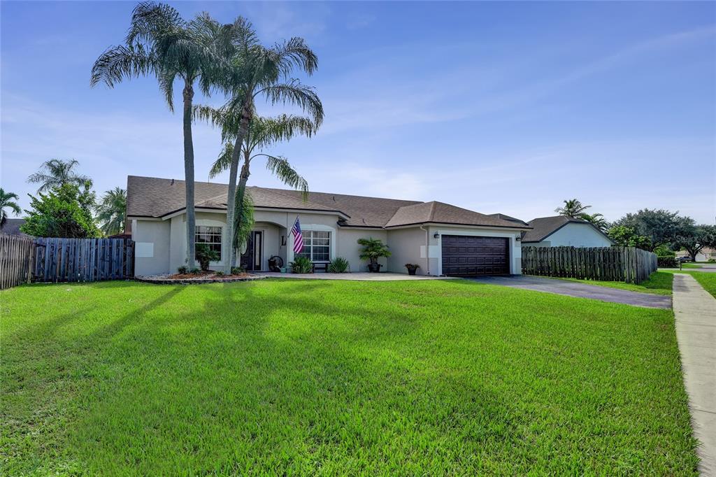 A single-story house with a brown roof, garage, and palm trees in the front yard — 1156 SW 149 LANE, SUNRISE, FL