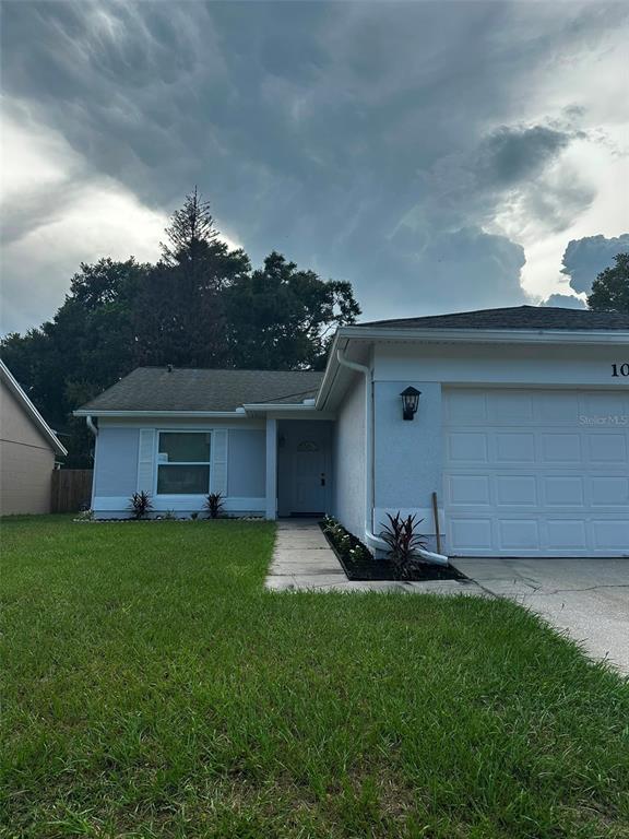 A single-story house with a white garage, a front walkway, and a cloudy sky above — 1060 DEES DRIVE, OVIEDO, FL