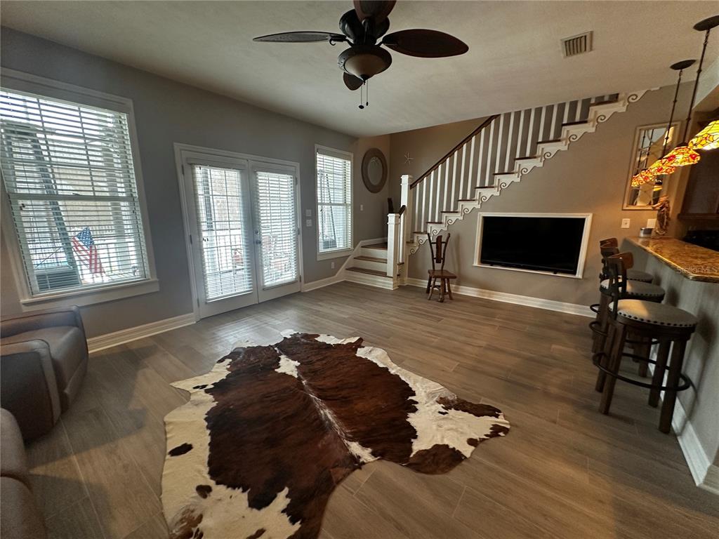 A kitchen with a breakfast bar, wooden stools, and a television built into the wall — 206 SE TENTH STREET UNIT 9, STEINHATCHEE, FL