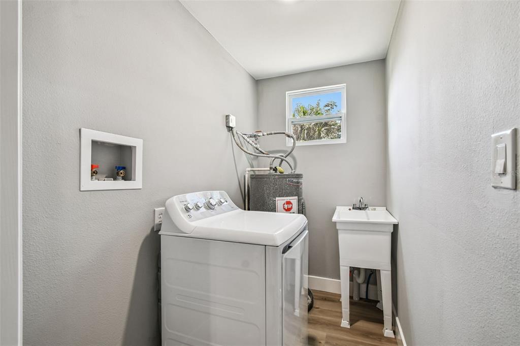A laundry room features a white washing machine, a utility sink, and a water heater — 3206 N 29TH STREET, TAMPA, FL
