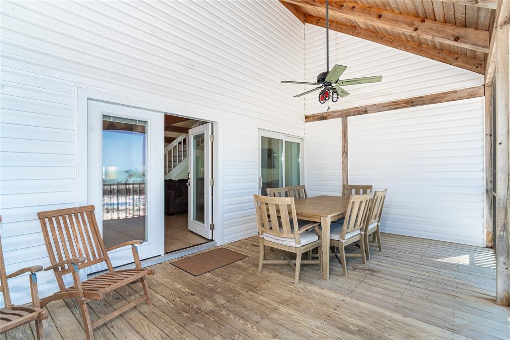 A wooden deck features a dining set, a lounge chair, and a ceiling fan — 360 S GULF BOULEVARD, PLACIDA, FL