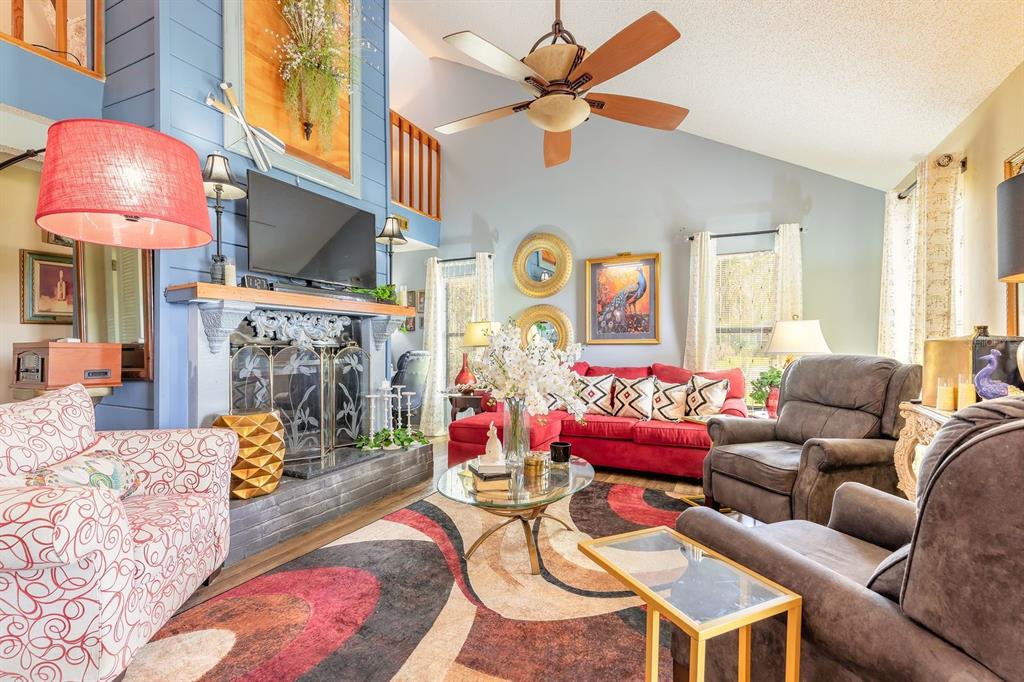A living room features a fireplace, a red sofa, patterned armchairs, and a ceiling fan — 3130 ROYAL PALM DRIVE, EDGEWATER, FL