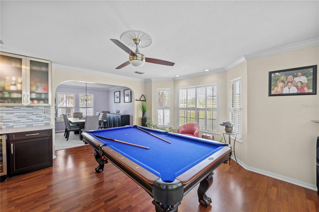 A game room features a blue pool table, dark wood flooring, and an adjacent dining area — 1623 SE 29TH TERRACE, OCALA, FL