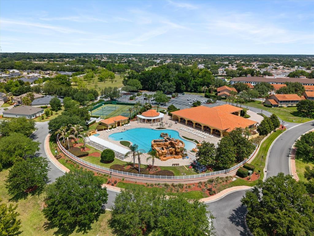 An aerial view of a community clubhouse featuring a swimming pool, tennis courts, and parking — 5336 EDGEWATER WAY UNIT 11, OXFORD, FL