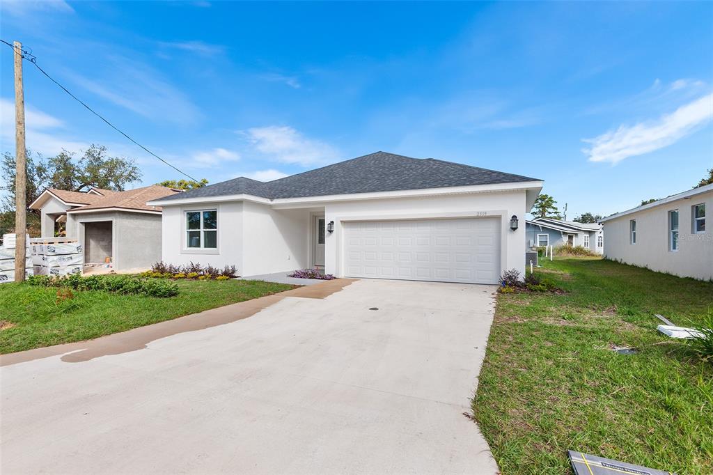 A newly constructed white house with a two-car garage and a concrete driveway — 2519 AVENUE E SW, WINTER HAVEN, FL