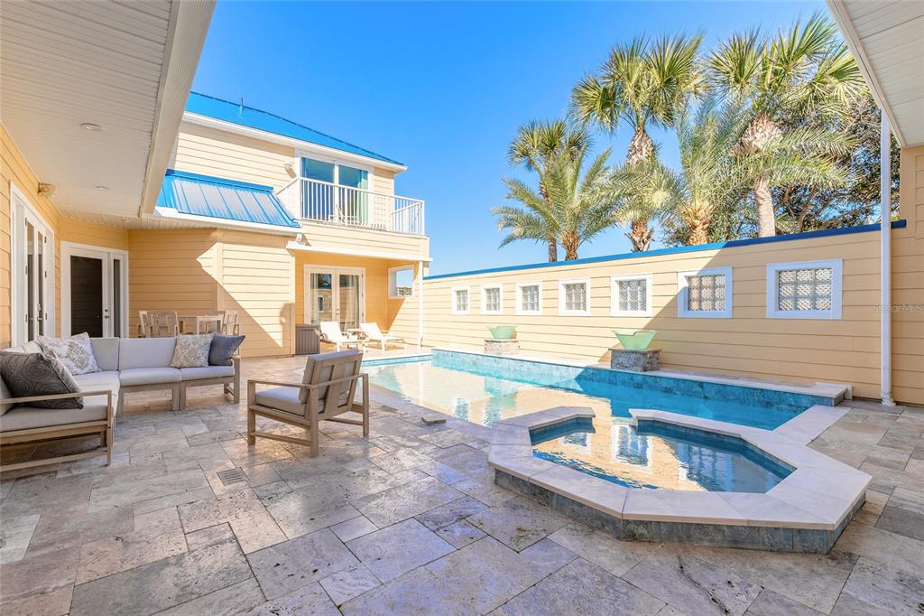 A patio features a swimming pool, a hot tub, outdoor seating, and a yellow house — 4641 RIVERWALK VILLAGE COURT, PONCE INLET, FL
