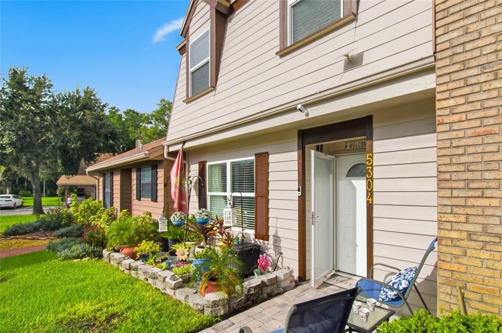 The exterior of a two-story house features light siding, a brick pillar, and a front patio — 5304 BRADBURY COURT, TAMPA, FL