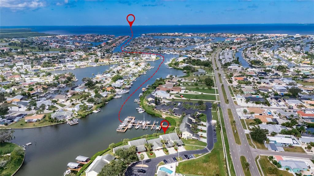 An aerial view shows a waterfront residential complex with a boat dock and canal access — 620 YARDARM DRIVE UNIT 10, APOLLO BEACH, FL