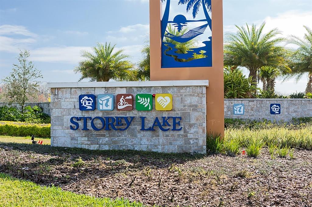 A stone monument sign for Storey Lake stands outdoors with palm trees in the background — 2961 SIMILE STREET, KISSIMMEE, FL