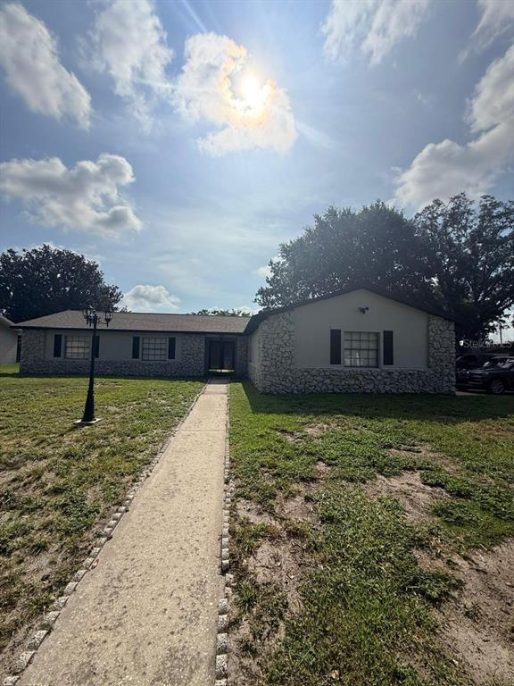 A single-story house with a stone facade, dark shutters, and a front lawn — 1241 ANGELINE AVENUE, ORLANDO, FL
