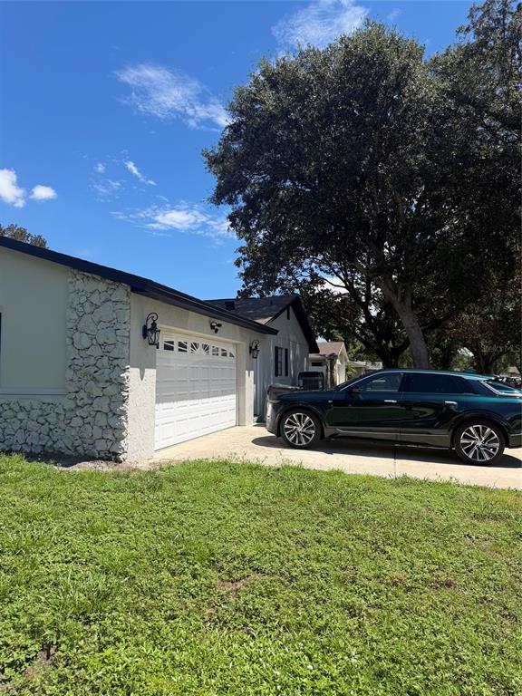 A single-story house with a stone facade and a concrete walkway leading to the entrance — 1241 ANGELINE AVENUE, ORLANDO, FL