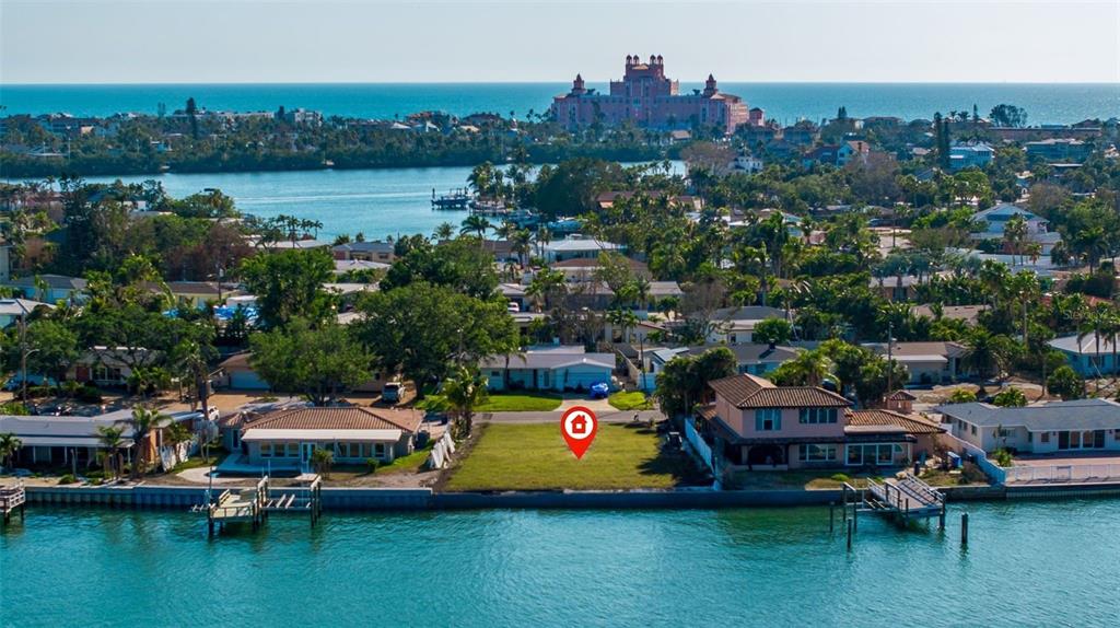 An aerial view shows a vacant waterfront lot situated between two houses along a canal — 500 BELLE POINT DRIVE, ST PETE BEACH, FL
