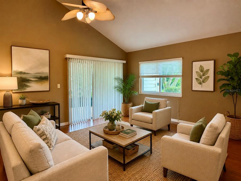 A kitchen features white cabinets, black countertops, a subway tile backsplash, and wood-look flooring — 2617 FOREST RUN COURT, CLEARWATER, FL