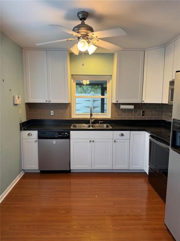 An empty dining room features light blue walls, wood-look flooring, and a central chandelier — 2617 FOREST RUN COURT, CLEARWATER, FL