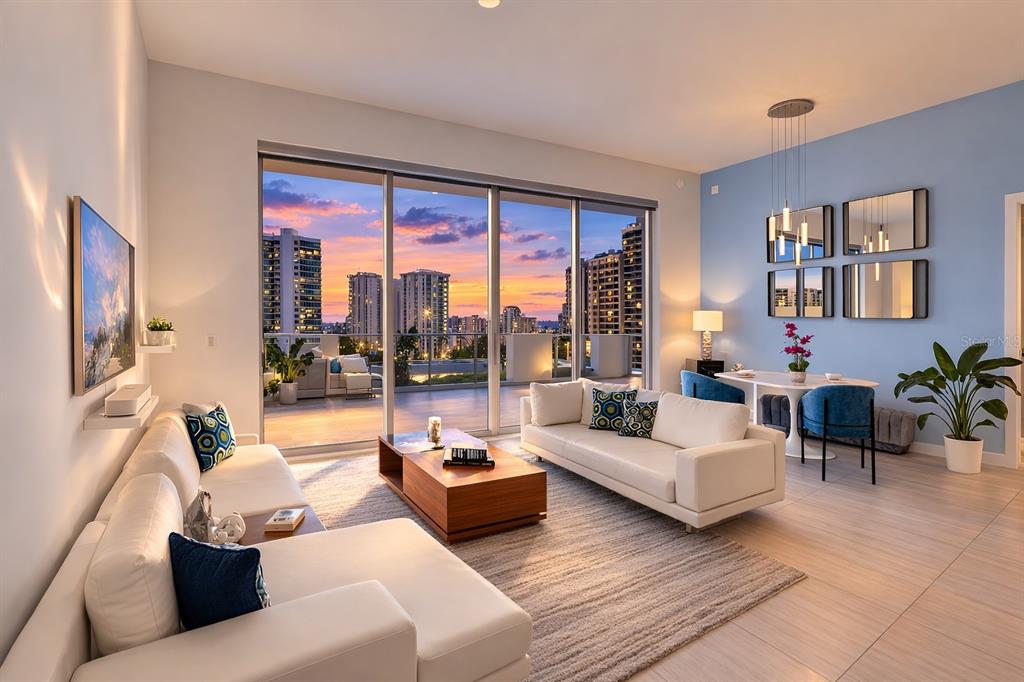 A modern living room with white sofas, a wooden coffee table, and a balcony view — 301 QUAY COMMONS UNIT 509, SARASOTA, FL