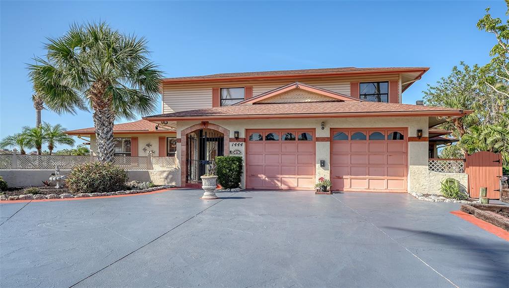 A two-story house with a two-car garage and a paved driveway under a clear sky — 1444 RIDGEWOOD LANE, SARASOTA, FL