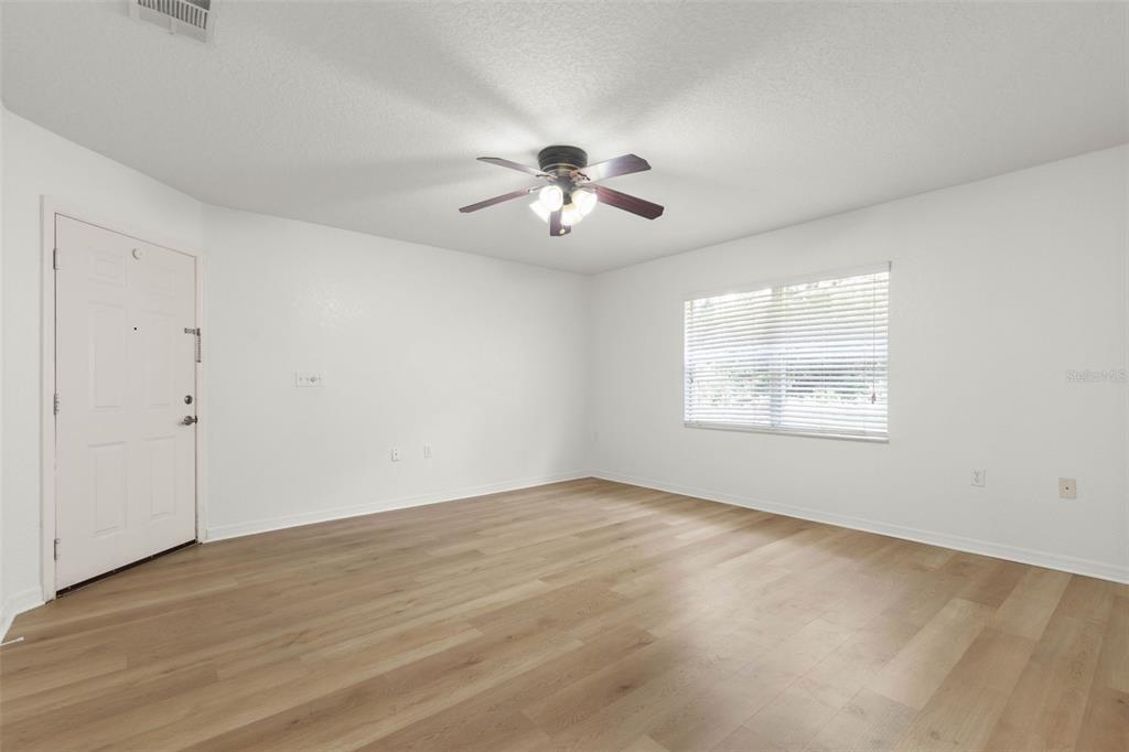 An empty room with white walls, light wood-look flooring, a ceiling fan, and a window — 4600 E MOODY BOULEVARD UNIT 7H, BUNNELL, FL