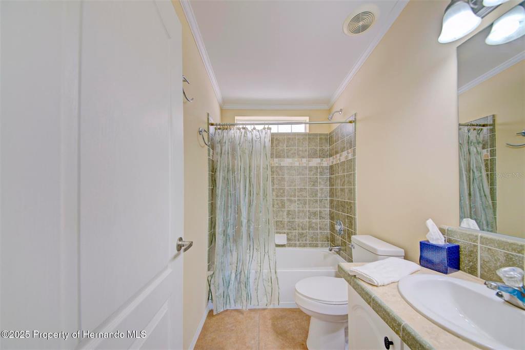 This bathroom features a shower-tub combination with tiled walls, a vanity, and a toilet — 9292 DENMARSH DRIVE, BROOKSVILLE, FL