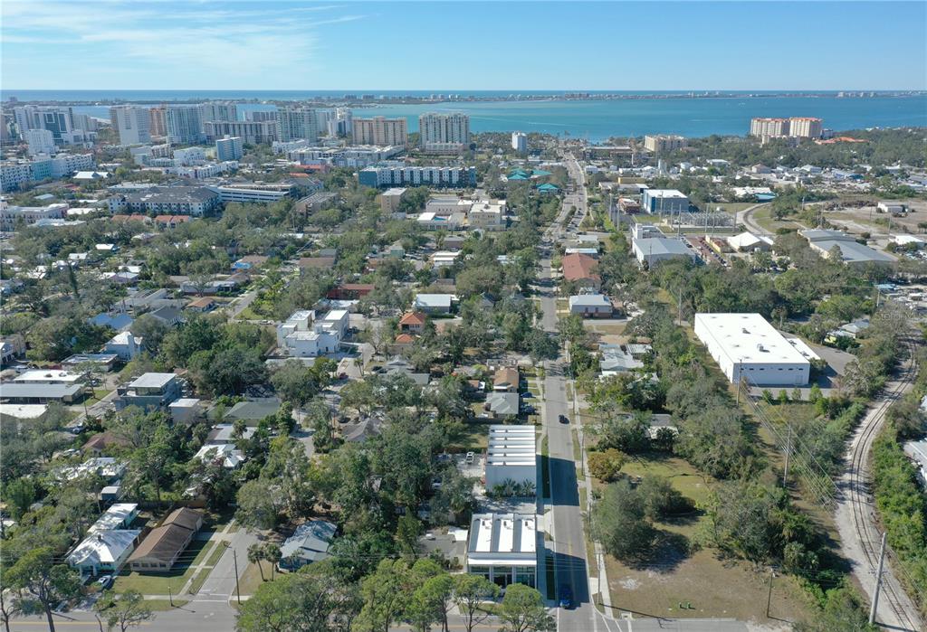An aerial view shows a residential neighborhood with a street leading toward the distant bay — 1744 10TH STREET, SARASOTA, FL