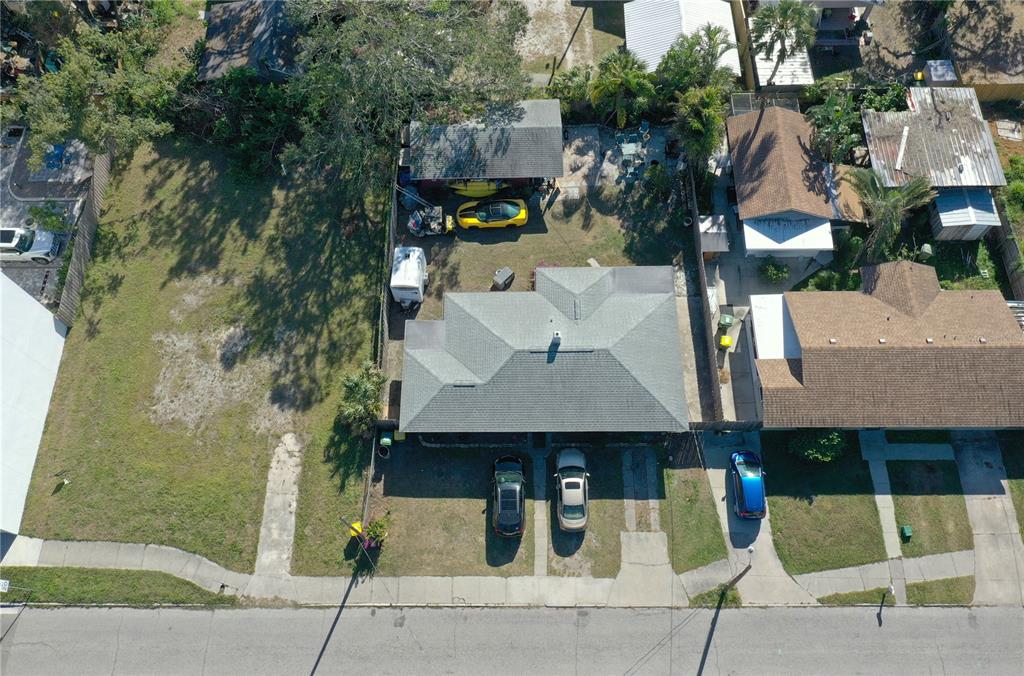 An aerial view shows a single-story house with a gray roof, driveway, and backyard garage — 1744 10TH STREET, SARASOTA, FL