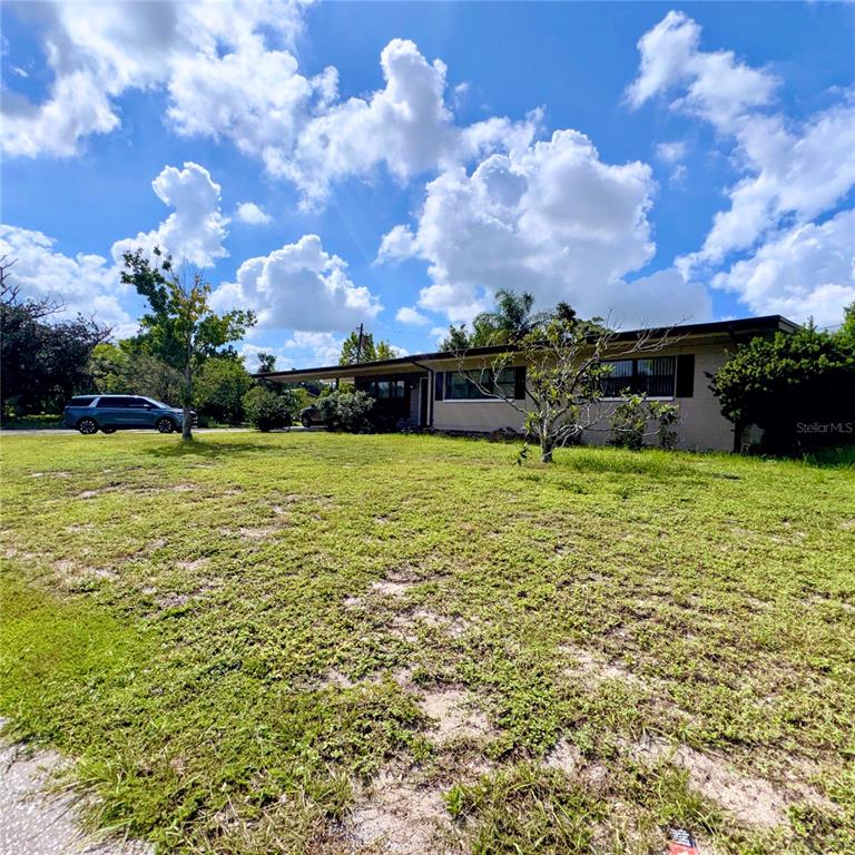 A single-story house with a flat roof and a large, grassy front yard — 105 DRUID HILLS ROAD, TEMPLE TERRACE, FL