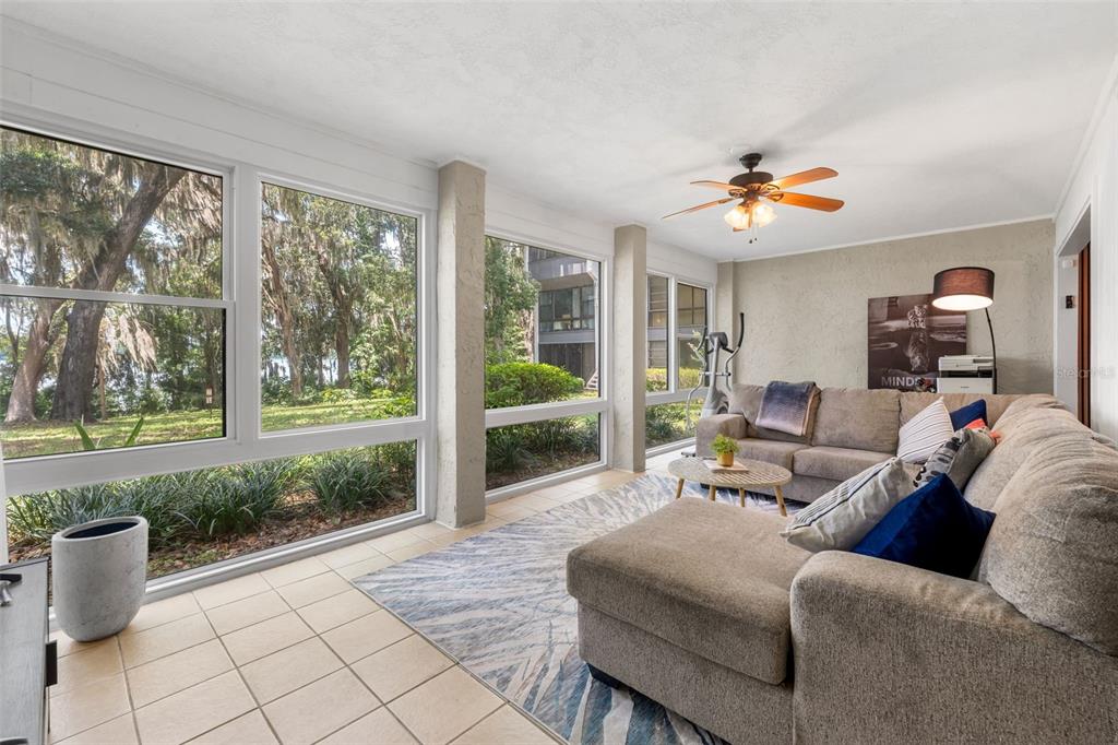 A sunroom with large windows, tile flooring, a sectional sofa, and a ceiling fan — 2660 SW 14TH DRIVE, GAINESVILLE, FL