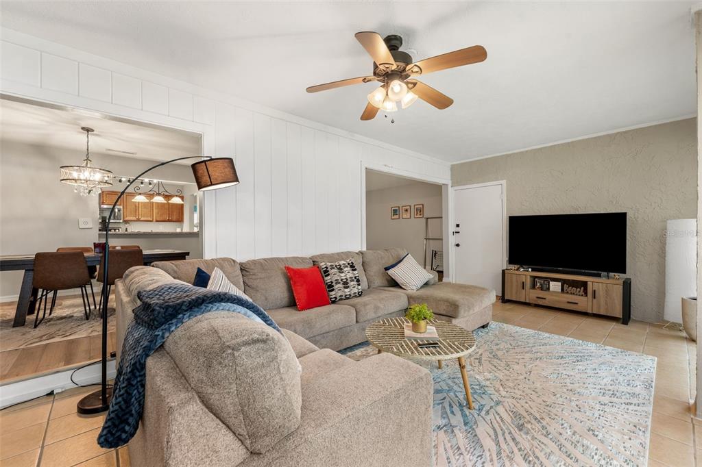 A living room features a sectional sofa, a television on a console, and a ceiling fan — 2660 SW 14TH DRIVE, GAINESVILLE, FL
