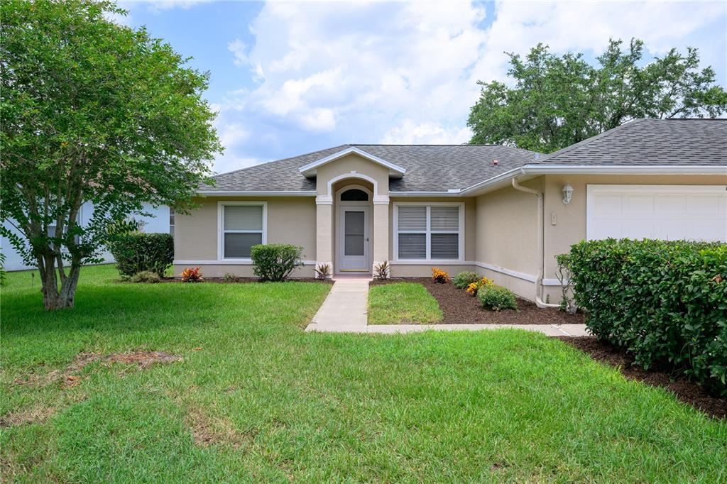 A single-story house with a beige stucco exterior, a gray shingled roof, and a front walkway — 1712 ARASH CIRCLE, PORT ORANGE, FL