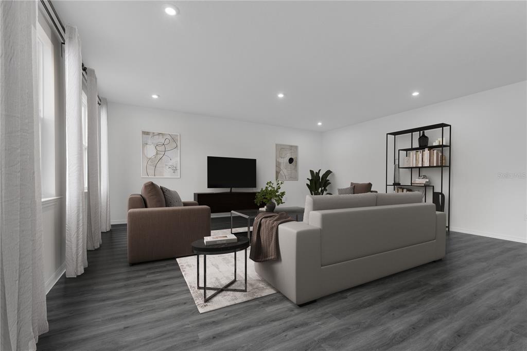 A living room features dark wood-look flooring, a gray sofa, a brown armchair, and shelving — 12907 CARA COURT, GRAND ISLAND, FL
