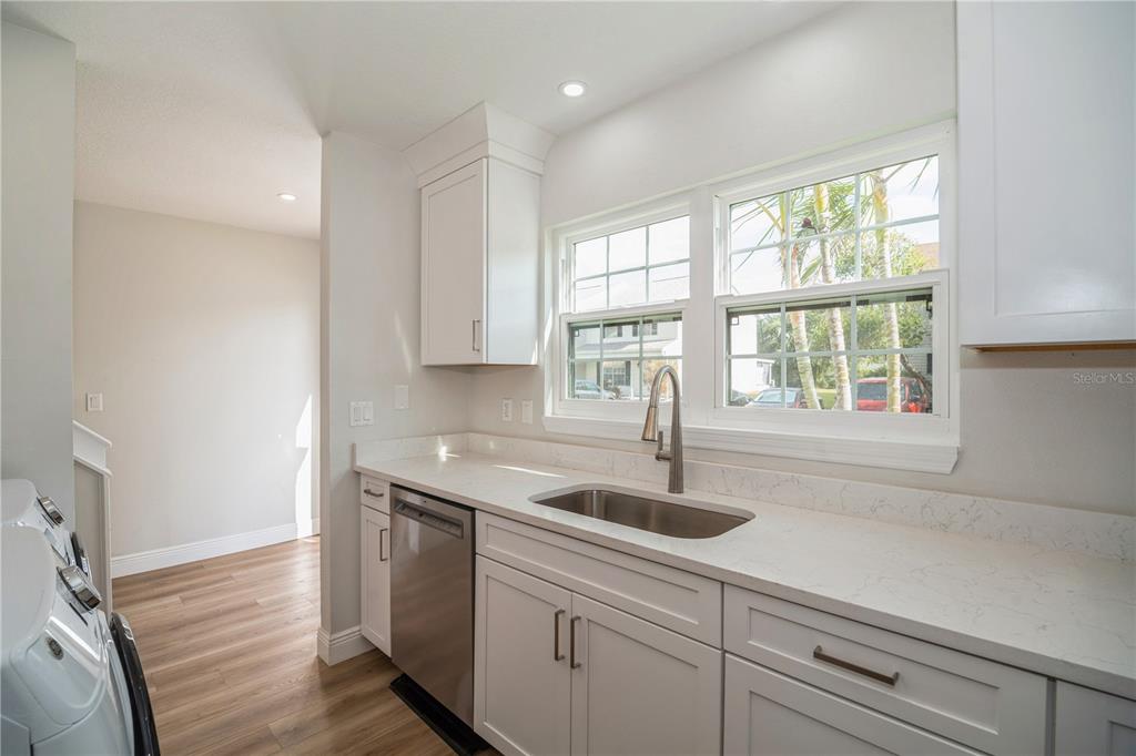 A kitchen with white cabinets, quartz countertops, a stainless steel sink, and a dishwasher — 2018 MANOR DRIVE NE, PALM BAY, FL
