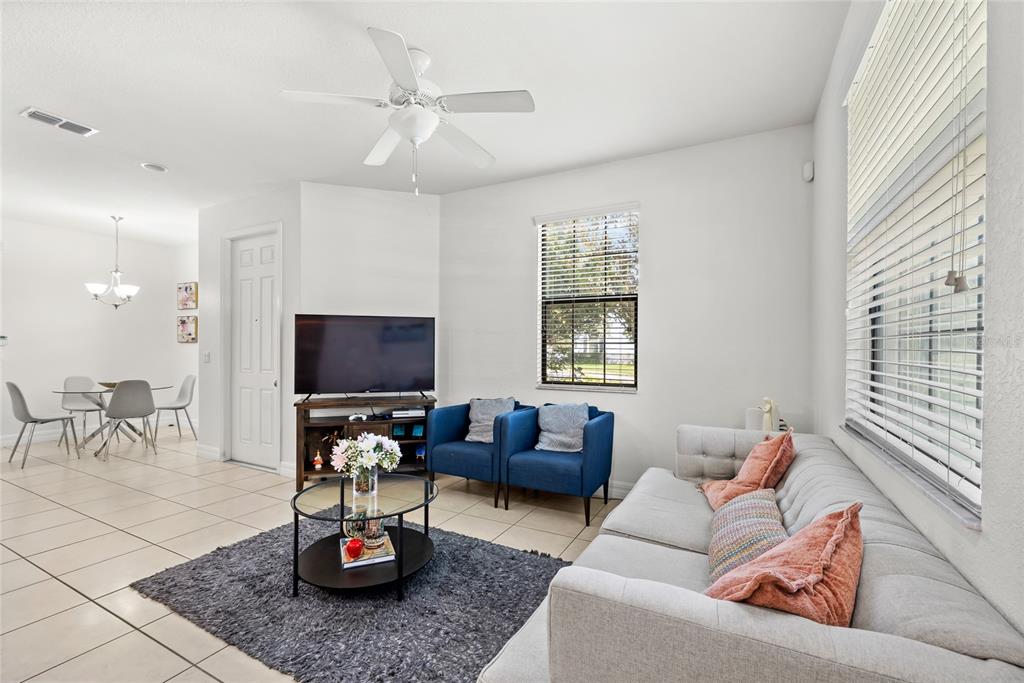 A kitchen features wood cabinets, granite countertops, stainless steel appliances, and a breakfast bar with stools — 10155 EAGLE CREEK CENTER BOULEVARD, ORLANDO, FL