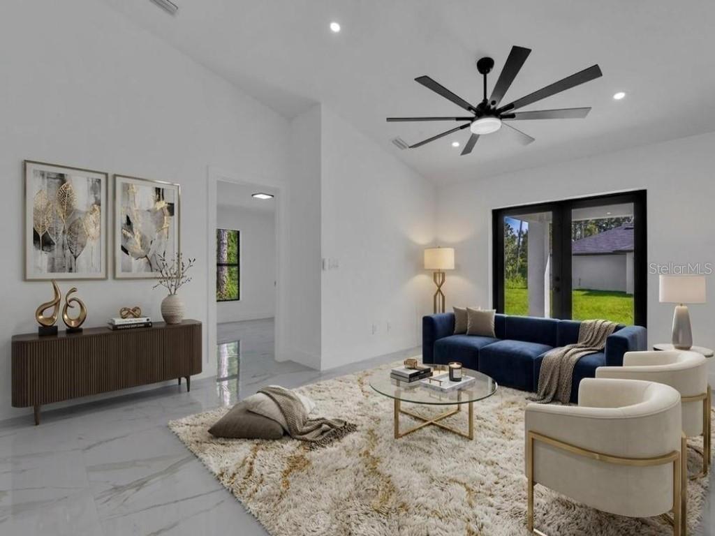 A modern living room features a blue sofa, white armchairs, a glass coffee table, and tile flooring — 4747 13TH STREET SW, LEHIGH ACRES, FL