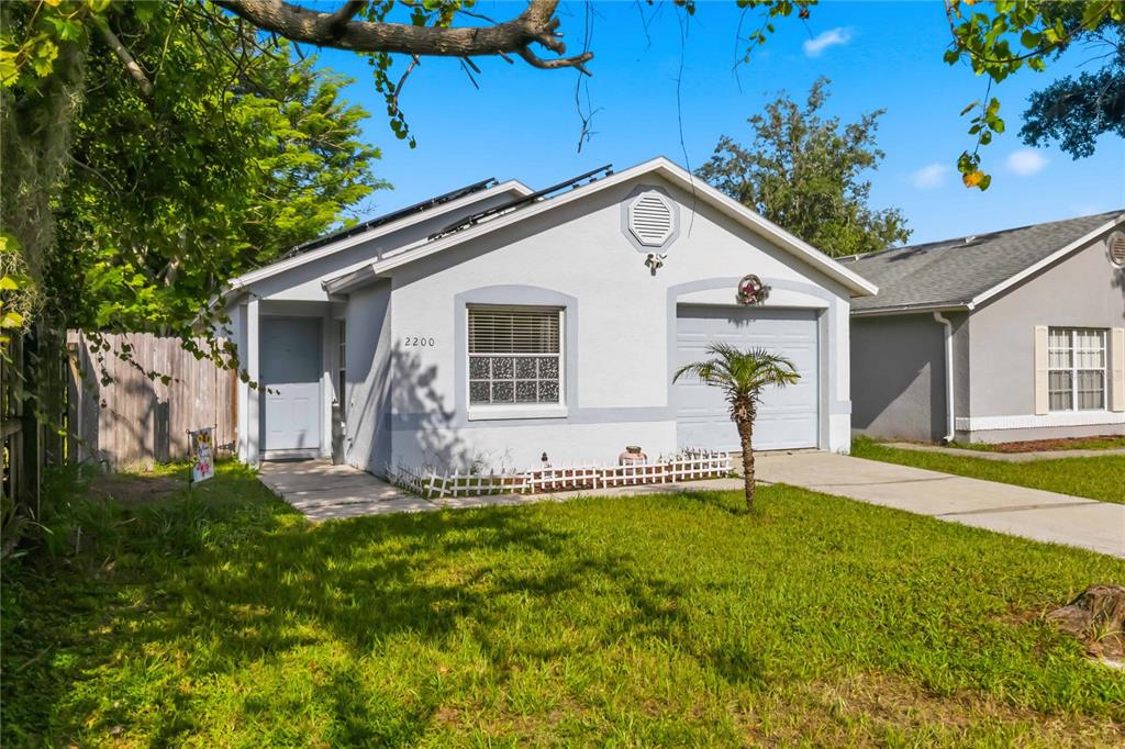 A concrete walkway leads to the front door of a house with a wooden fence — 2200 ROSE BROOK COURT, ORLANDO, FL