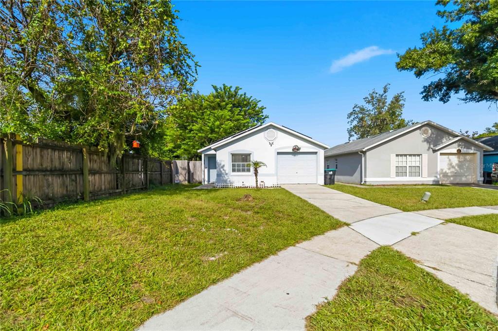 A single-story house with a white stucco exterior, a garage, and a concrete driveway — 2200 ROSE BROOK COURT, ORLANDO, FL