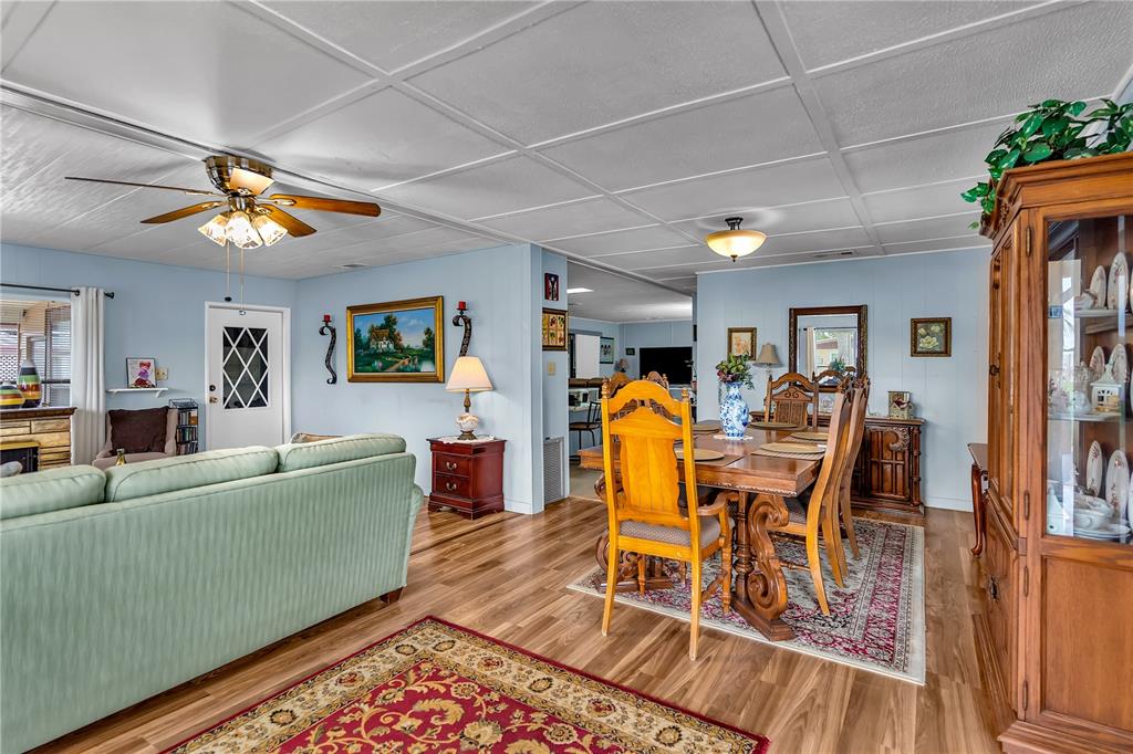 A living and dining area features light blue walls, wood-look flooring, and a ceiling fan — 38546 STAFFORD DRIVE, ZEPHYRHILLS, FL