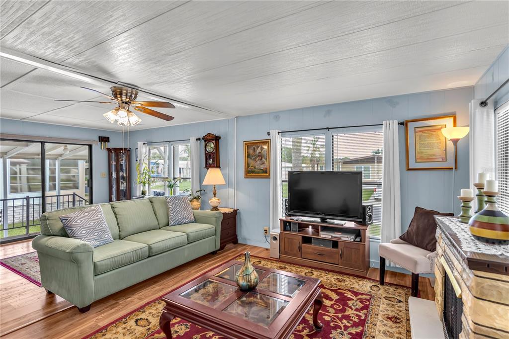 A living room features a green sofa, a wooden coffee table, and a television console — 38546 STAFFORD DRIVE, ZEPHYRHILLS, FL