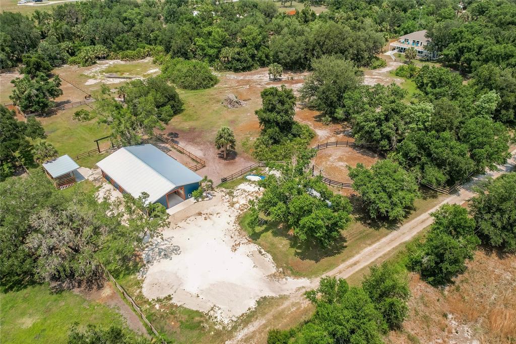 An aerial view shows a metal barn, a round pen, and a house on acreage — 9325 SW LIPE ROAD, ARCADIA, FL