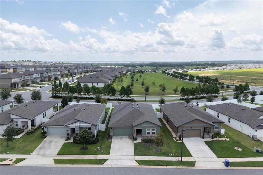 An aerial view of a suburban neighborhood featuring several single-family homes with driveways and lawns — 2098 HUNTSMAN RIDGE ROAD, MINNEOLA, FL