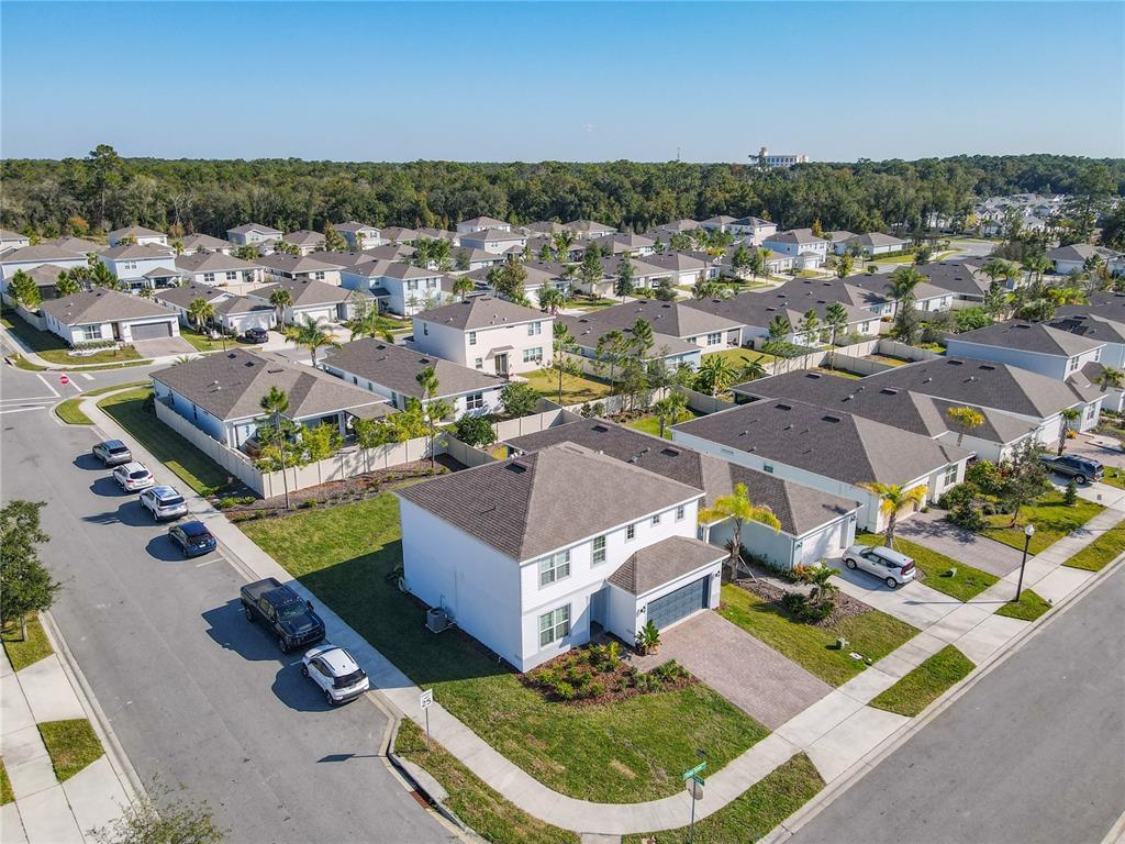 An aerial view shows a suburban neighborhood with single-family homes, paved streets, and parked cars — 2248 CANOPY TERRACE BOULEVARD, DELAND, FL