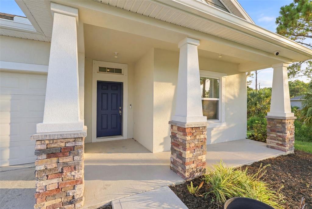 An entryway with a white front door and an adjacent room featuring wood-look flooring — 242 HERITAGE STREET SW, PALM BAY, FL