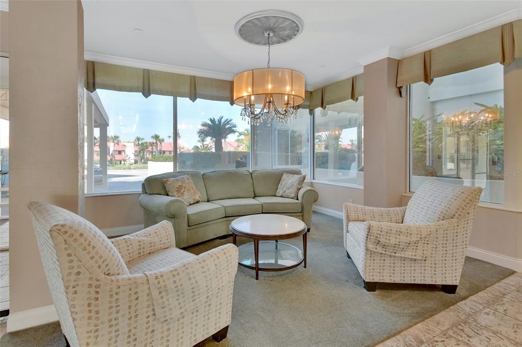 A living area features a green sofa, two patterned armchairs, and a central chandelier — 2937 S ATLANTIC AVENUE UNIT 2008, DAYTONA BEACH SHORES, FL