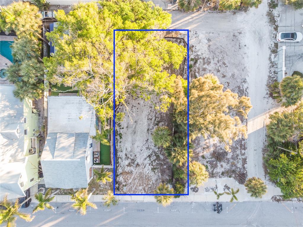 An aerial view shows a vacant, rectangular lot outlined in blue between two existing properties — 110 4TH AVENUE, ST PETE BEACH, FL