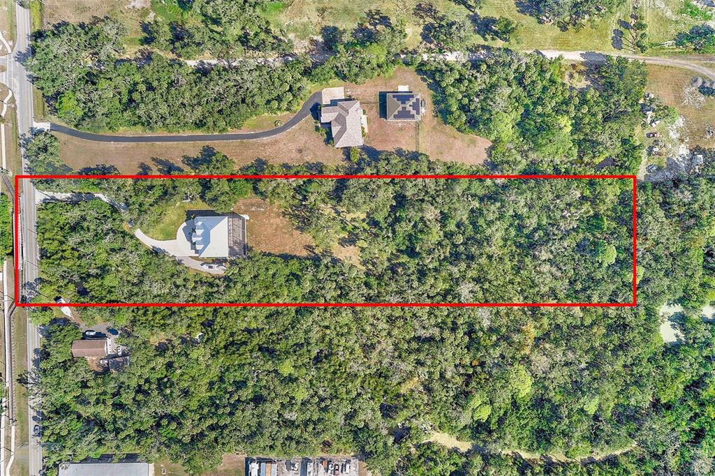 An aerial view shows a rectangular property lot containing a house with a driveway — 3410 26TH AVENUE E, BRADENTON, FL
