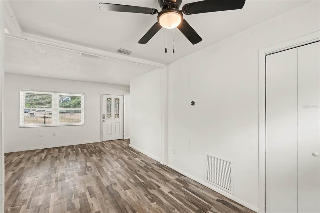 A room with white walls, wood-look flooring, a ceiling fan, and a white closet door — 313 MILLER MAC ROAD, APOLLO BEACH, FL