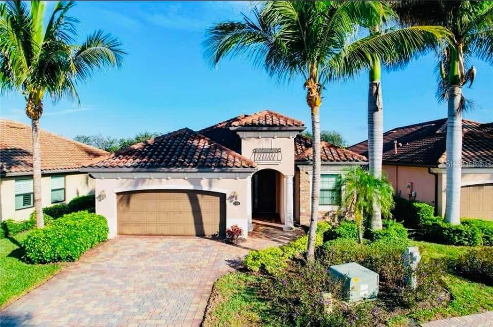 A single-story house with a tile roof, a two-car garage, and palm trees in front — 2902 AVIAMAR CIRCLE, NAPLES, FL