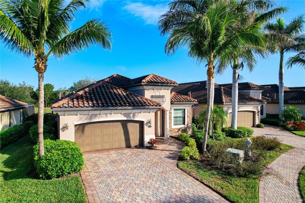 A single-story house with a tile roof, a paved driveway, and several tall palm trees — 2902 AVIAMAR CIRCLE, NAPLES, FL