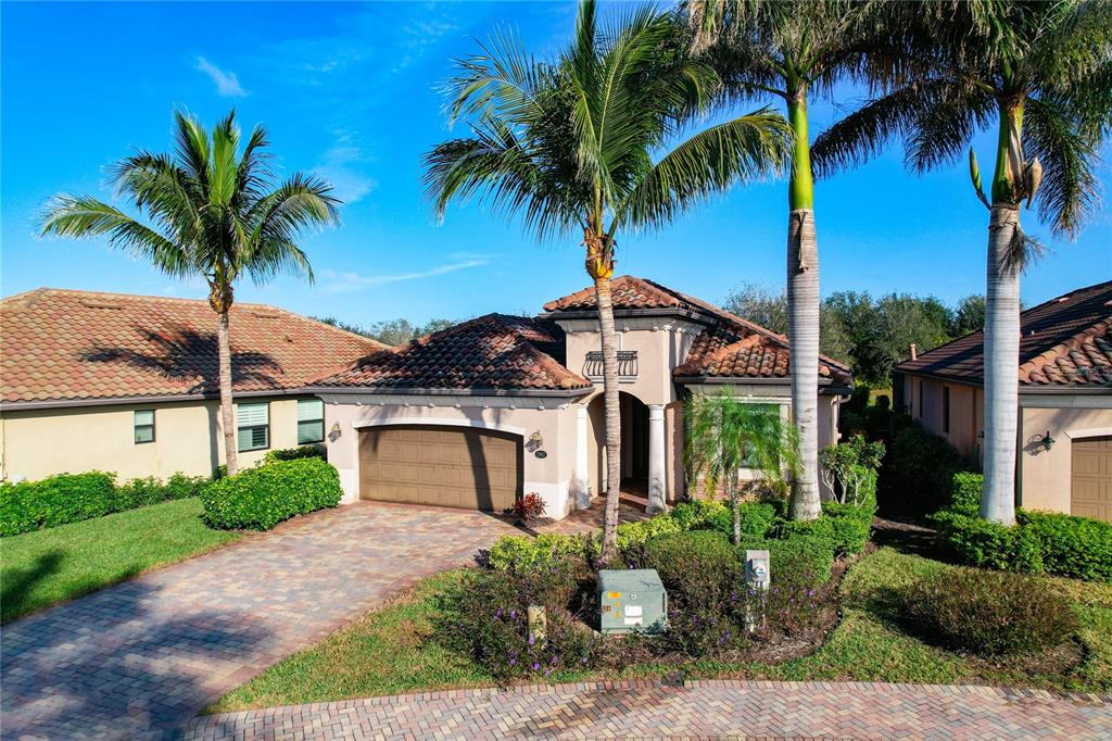 A single-story house with a tiled roof, a two-car garage, and palm trees in front — 2902 AVIAMAR CIRCLE, NAPLES, FL