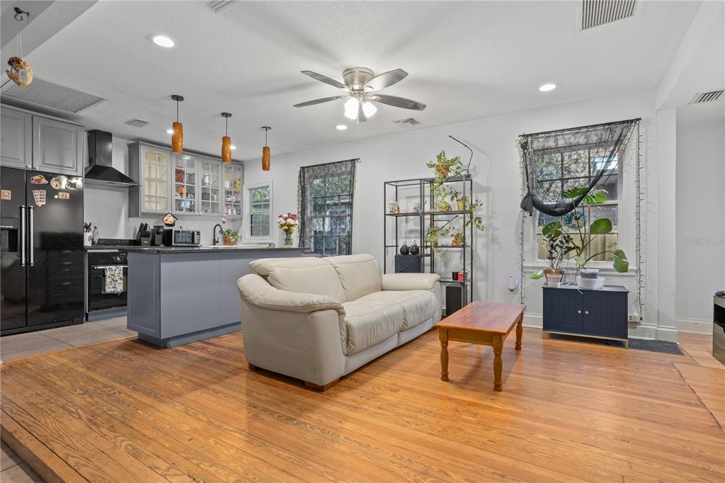 A living room features a white sofa, wooden coffee table, hardwood floors, and a ceiling fan — 816 E JEFFERSON STREET, ORLANDO, FL